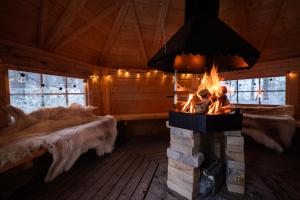 una camera con camino in una baita di tronchi di Arctic Bear Resort - Lapland - Aurora suite - Sauna - Northern Lights a Ranua