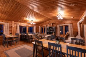 un soggiorno con soffitti e tavoli in legno e sedie. di Arctic Bear Resort - Lapland - Aurora suite - Sauna - Northern Lights a Ranua