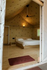 een slaapkamer met een bed in een houten plafond bij The Wilds Villa Gir Jungle Stay with Swimming Pool in Sasan Gir +100 foto's