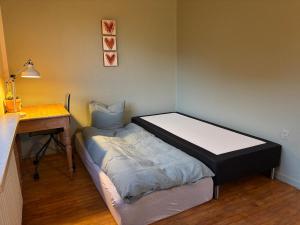 une petite chambre avec un lit et un bureau dans l'établissement Grandmothers home, à Randers