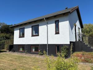 une maison blanche avec des fenêtres noires et une cour dans l'établissement Grandmothers home, à Randers