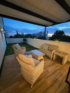 eine Terrasse mit Korbstühlen und Sofas auf dem Dach in der Unterkunft Corvera Golf Lexu in Corvera