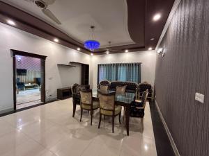 Un comedor con una mesa de cristal y sillas. en Vista Lodge Guest House, en Islamabad