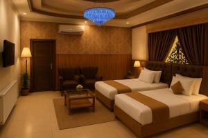 una habitación de hotel con dos camas y una mesa en Vista Lodge Guest House, en Islamabad