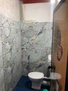 a bathroom with a toilet and a stone wall at nandanam villlas in Guruvāyūr +52 photos