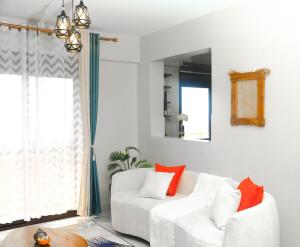 a living room with a white couch and a mirror at Myra Luxury Homes in Kololo- Your Family Oasis in Kampala +26 photos