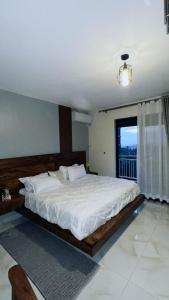 a large bed in a room with a window at Myra Luxury Homes in Kololo- Your Family Oasis in Kampala