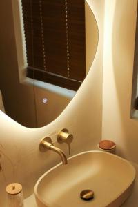 une salle de bain avec un lavabo et un miroir dans l'établissement Casa Cinta - Sanctuaire Balinais avec Baignoire Balnéo et Cinéma Privé, à Croix 20 autres photos