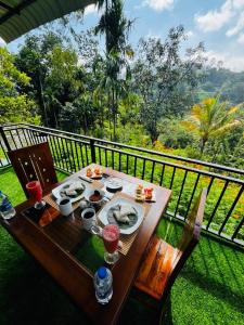 a wooden table with plates of food on a balcony at The Aurelian in Ella +65 photos