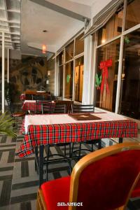 un restaurante con mesas y sillas con un lazo rojo en Silantoi hotel, en Gatunga