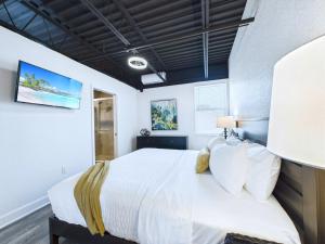une chambre avec un grand lit avec des draps blancs dans l'établissement Bright Modern Loft By Port & Beaches -unit 206, à Cap Carnaveral