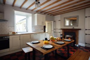 a kitchen with a wooden table with fruits on it at Homely Cottage - Beaches, Costal walks, Castles in Newchapel