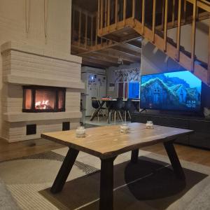a living room with a table and a fireplace at Aurora Haven in Vanttauskoski