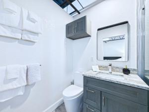 a white bathroom with a sink and a mirror at Stylish Loft Minutes From Beach & Port - Unit 204 in Cape Canaveral +23 photos