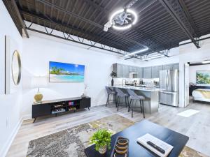 an open living room with a kitchen and dining area at Stylish Loft Minutes From Beach & Port - Unit 204 in Cape Canaveral