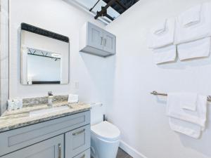 une salle de bain blanche avec un lavabo et un miroir dans l'établissement Sleek Coastal Loft Close To Port & Beach -unit 205, à Cap Carnaveral 23 autres photos