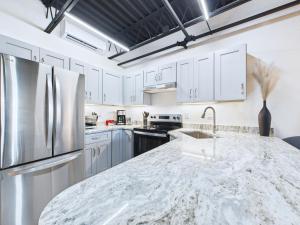 une cuisine avec des armoires blanches et un comptoir en marbre dans l'établissement Sleek Coastal Loft Close To Port & Beach -unit 205, à Cap Carnaveral