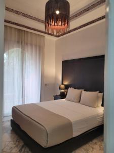 马拉喀什Palmeraie village 2 , les jardins de la palmeraie 2的一间带大床和吊灯的卧室