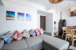 a living room with a gray couch with colorful pillows at Yokosuka Royal Bari House 703 in yokosuka chuo station in Yokosuka