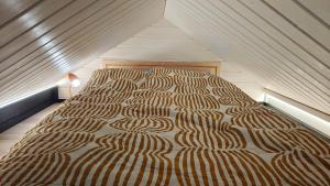 un grand lit dans une chambre avec un plafond en bois dans l'établissement Cottage on the banks of the Ounasjoki River, à Rovaniemi