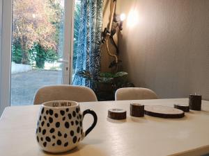 a coffee cup sitting on top of a table at Appartement Jungle Cosy - Bureau & Fibre - Proche Futuroscope in Jaunay-Marigny