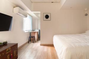 een slaapkamer met een bed en een flatscreen-tv bij stay105행궁 in Suwon