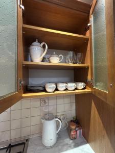 a cupboard filled with dishes and bowls in a kitchen at Apartament na wyłączność - Tarnowskie Góry - Strzybnica in Tarnowskie Góry