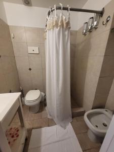 ein Badezimmer mit Toilette und Duschvorhang in der Unterkunft FLAT Fleming Martinez in Martínez