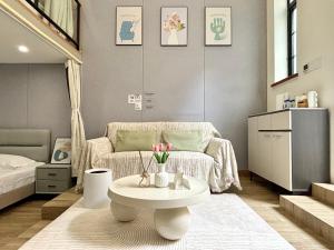 Zimmer mit einem Tisch, einem Bett und einem Sofa in der Unterkunft Private Garden Courtyard in Shanghai Old Villa Near City Center Nanjing West Road Metro Station in Shanghai