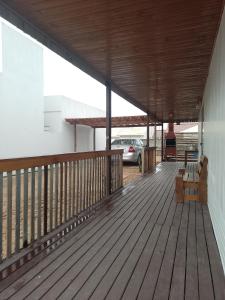 a wooden deck with a car parked in a parking lot at Casa container in São Lourenço do Sul