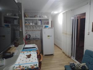 a kitchen with a refrigerator and a table in it at Casa container in São Lourenço do Sul