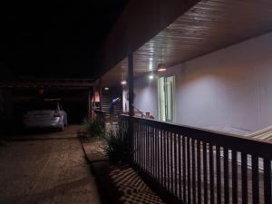 a man standing on the porch of a house at night at Casa container in São Lourenço do Sul