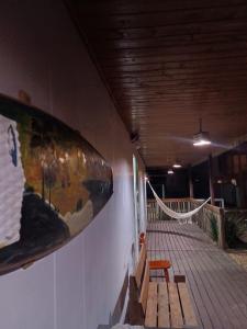 a room with a surfboard on the wall and a bench at Casa container in São Lourenço do Sul +3 photos