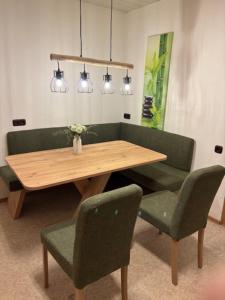 a wooden table with two green chairs and a wooden table and chairs sidx sidx sidx at Ferien - Monteurwohnung Roding in Roding +1 photo