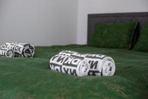 a bed with green sheets with tires on it at Moonloungeresort in Kalviai +43 photos