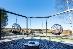 a swing set with two swings and a grill at Moonloungeresort in Kalviai