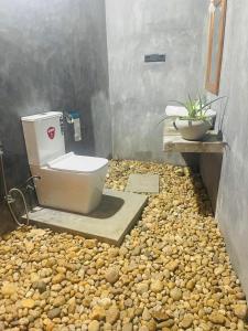 a bathroom with a toilet sitting on a pile of rocks at Private Organic House in Udawalawe