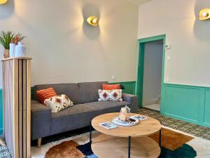 ein Wohnzimmer mit Sofa und Tisch in der Unterkunft Maison 2 chambres avec bureau - Proche gare in Saint-Omer