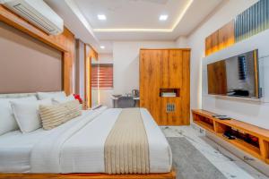 a bedroom with a large white bed and a television at Hotel Deol's Paradise in Indore +40 photos