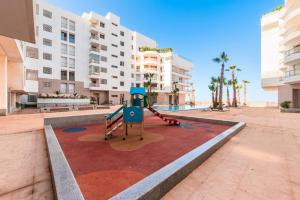 Oulad AkkouにあるAzur Apartment pool & designの建物のある中庭の真ん中にある遊び場