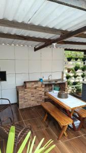 une cuisine extérieure avec une table et des bancs dans l'établissement Chalédri, à Chapada dos Guimarães
