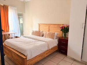 a bedroom with a bed and a vase of flowers at Mini Cottage Home in Johannesburg