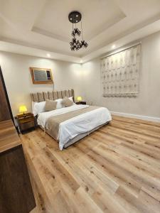 a bedroom with a large bed and wooden floors at comfort suite in Jeddah