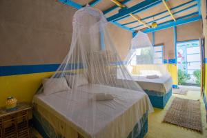 a bedroom with two beds with mosquito nets at Pharaohs Rest Luxor in Luxor
