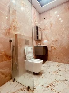 a bathroom with a toilet and a glass shower at Hotel Shri Ram Anadam Inn in Masodha