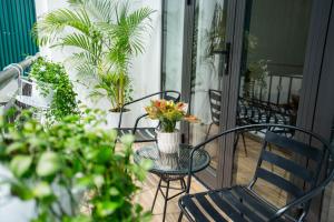 een tafel en stoelen op een veranda met planten bij Dimori homestay in Thôn Trường Giang
