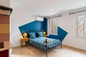 Bett in einem Zimmer mit blauer Wand in der Unterkunft L'étape Arlésienne in Arles + 24 Fotos