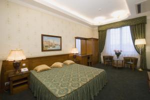 a hotel room with a bed and a table and chairs at Aton Hotel in Krasnodar