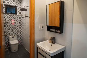 a bathroom with a sink and a toilet and a mirror at Dimori homestay in Thôn Trường Giang