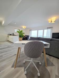 a living room with a table and a chair at Panorama trifft Gemütlichkeit in Nümbrecht